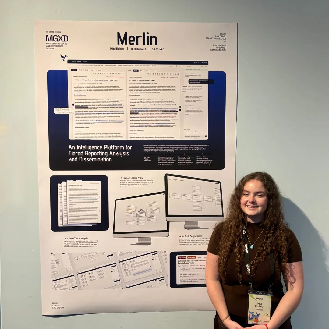 Mia standing beside the Merlin poster, an intelligence platform for tiered reporting analysis and dissemination
