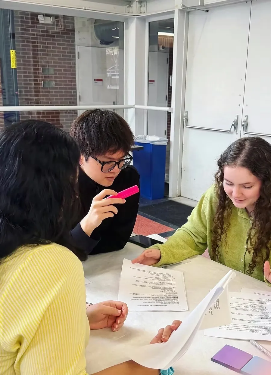 The Merlin team at a table, marking up printed reports with a highlighter